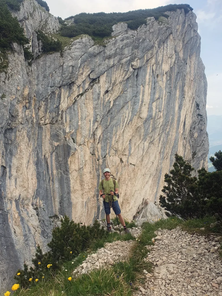 Man standing in front of a rock wall on the Austrian Alps.